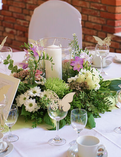 Eventscheune, Tischdekoration. Viel Grün, etwas Weiß. Pinke Akzente.