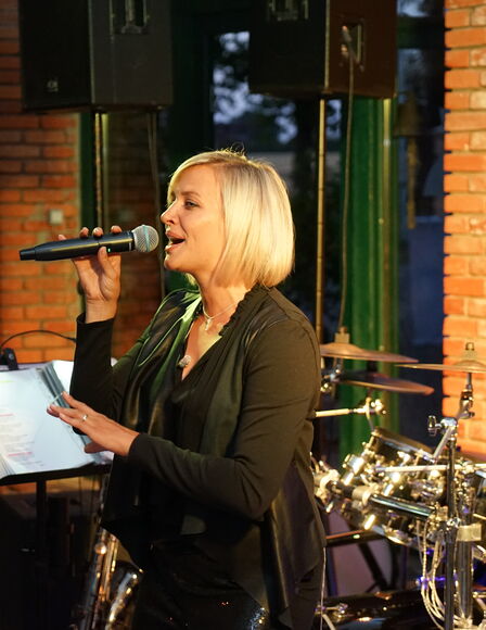Sängerin singt in Eventscheune. Im Hintergrund ein Schlagzeug.