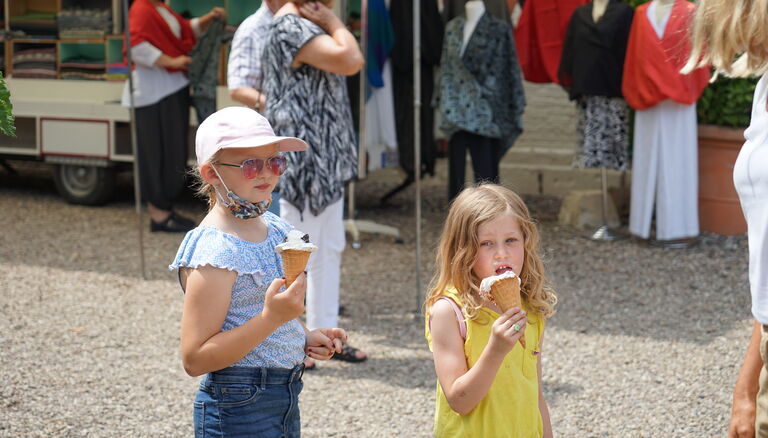 Zwei KInder, die je eine Eistüte halten, eines der Kinder hat Eis um den ganzen Mund herum geschmiert