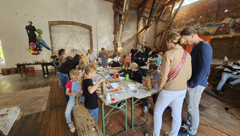 Kinder-Bastel-Event in Scheune, es sind mehrere Kinder und ein paar wenige Erwachsene zu sehen