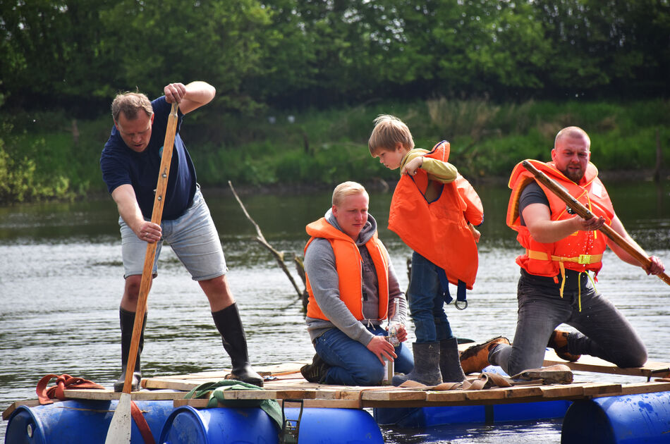 Zwei Jungen und zwei Männer auf einem Floß auf dem See