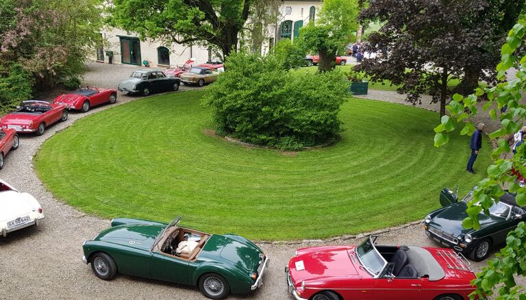Zahlreiche Oldtimer in Weiß, Rot und Grün sind auf dem Hopfplatz des Wittkielhofs geparkt.