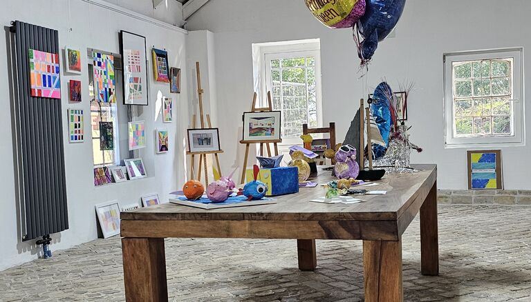 Dekorierter Holztisch und Asmus-Petersen Scheune, drei Helium-gefüllte Ballons sind daran festgebunden