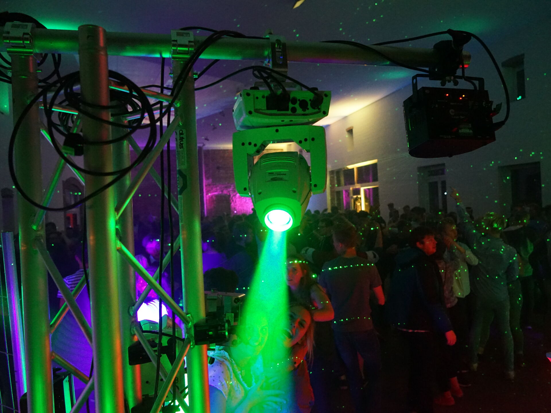 Vordergrund Gerüst mit grünen Leuchten, der Rest der SCheune ist voll mit Leuten