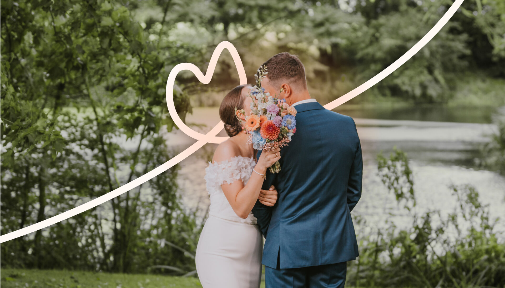 Brautpaar vor See, Brautstrauß verdeckt die Gesichter, hinter ihnen eine weiße Linie mit herzförmiger Schlaufe