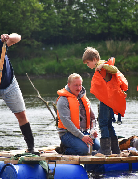 Zwei Jungen und zwei Männer auf einem Floß auf dem See