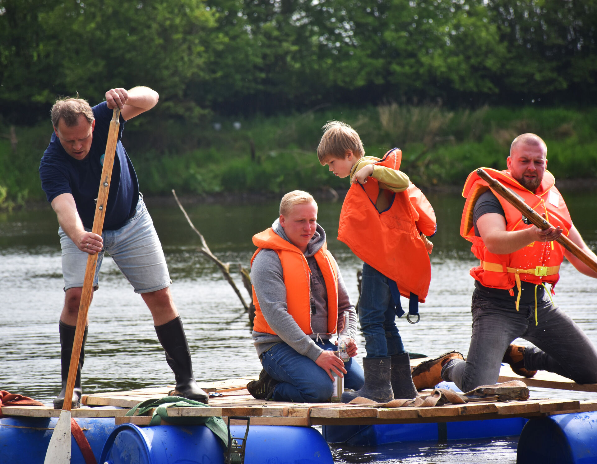 Zwei Jungen und zwei Männer auf einem Floß auf dem See