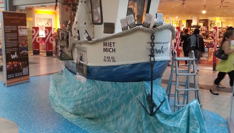 Fischkutter-Imbisstand aufgebaut im Fördepark, mit Decke als Wasserimitat
